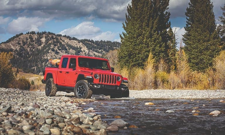 2020 Red Jeep Gladiator Rubicon Crossing a Rocky Creek