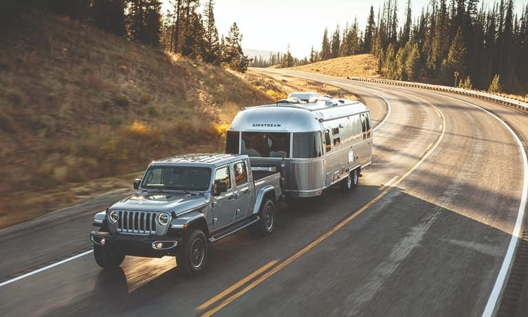 2020 Silver Jeep Gladiator Towing a Airstream on the Highway